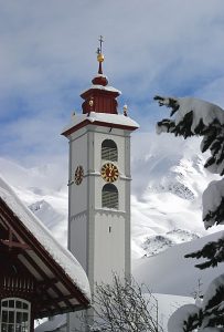 andermatt church tower in winter with snow